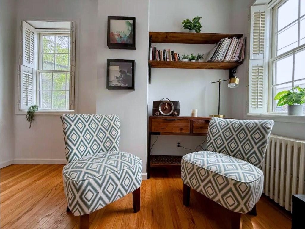 Two patterned accent chairs by a bookshelf